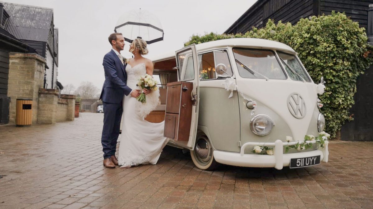 bride and groom standing next to VW split screen camper on their wedding day