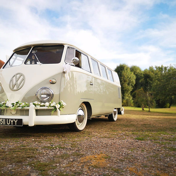 VW camper at a wedding with cream rose garland on the front bumper