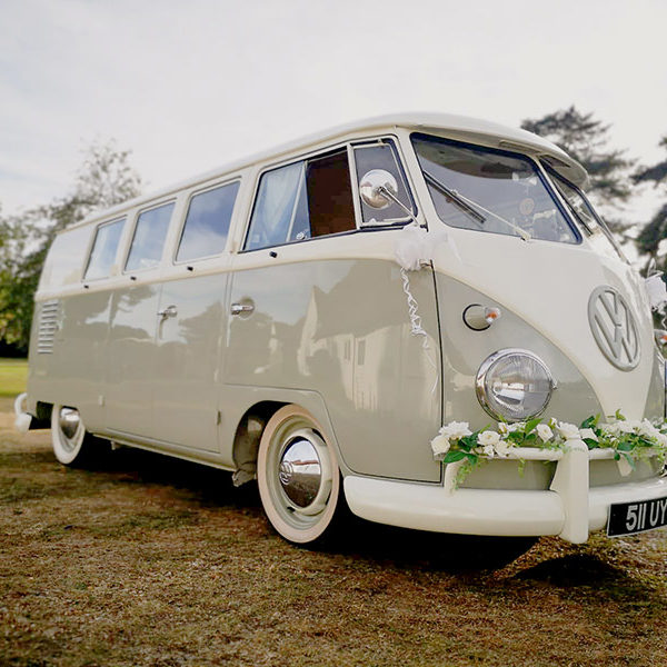 VW camper with cream rose wedding garland on the front bumper