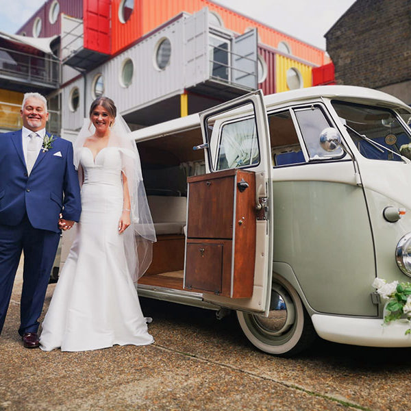 Bride and Father-of-the-Bride pose outside a wedding camper