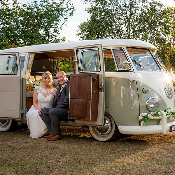 Bride and groom pose in VW camper