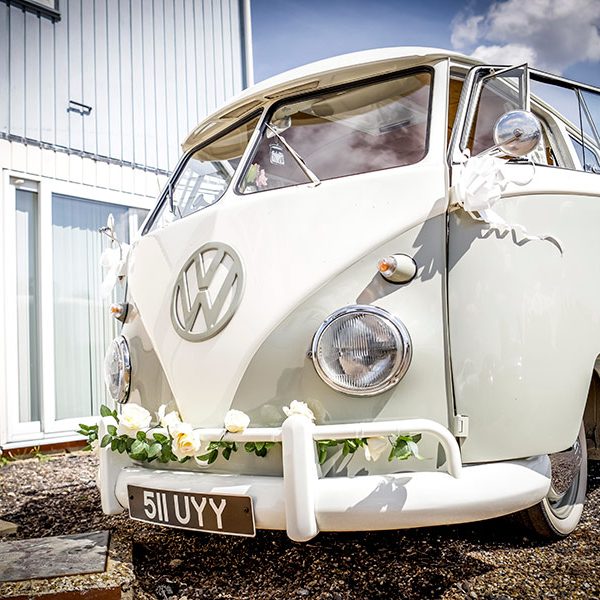VW split screen camper front view with wedding ribbons and flower garlands